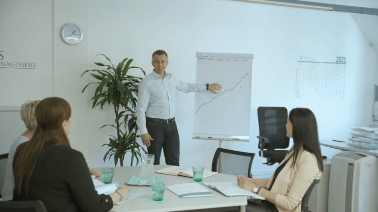 Mann zeigt eine Statistik auf dem Whiteboard